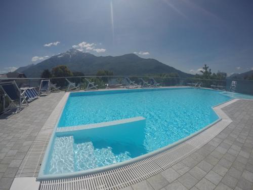 多马索露营维拉吉奥天堂酒店的一座蓝色的游泳池,后面是群山