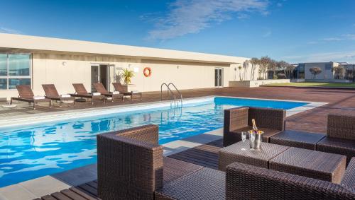 开普敦泻湖滩酒店及Spa的一个带藤椅和桌子的游泳池