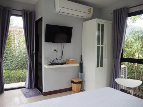 慕斯考艾福库斯度假山林小屋的卧室配有一张床,墙上配有电视。