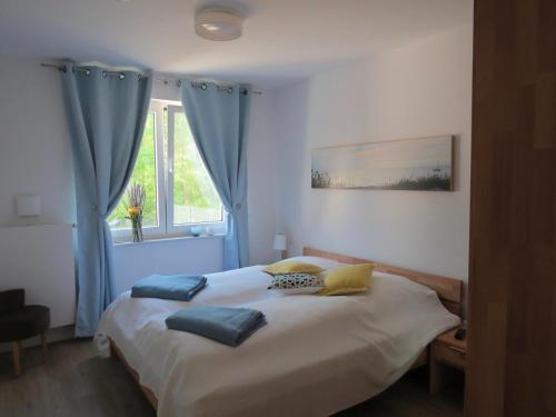 朱列斯拉赫Ferienwohnung Traumsegler的一间卧室配有一张带蓝色窗帘的床和一扇窗户