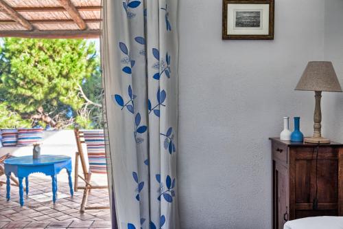 圣马里纳萨利纳Hotel Mercanti di Mare的一间设有桌子和布满蓝色花卉的窗帘的房间