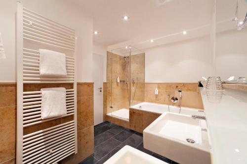 奥托博伊伦赫希AKZENT酿酒厂酒店的浴室配有水槽、淋浴和浴缸。