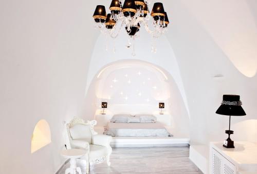 费拉阿斯特拉斯别墅酒店的白色卧室配有一张床和一个吊灯
