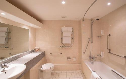 考文垂考文垂南柑橘可母帕斯酒店 的浴室配有盥洗盆、卫生间和浴缸。