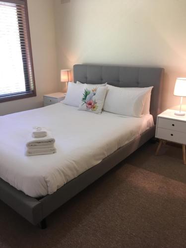 布赖特阿科恩度假屋的卧室配有一张带白色床单和枕头的大床。
