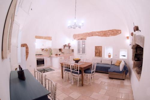 莫尔恰诺迪莱乌卡Petrarussa Dimora Storica的厨房以及带桌子和沙发的客厅。