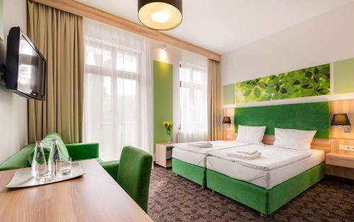 希维拉杜夫-兹德鲁伊Cottonina Hotel & Mineral SPA Resort的酒店客房配有一张床铺和一张桌子。