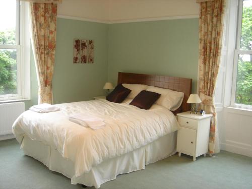 怀特黑Croft Hill Guest House的卧室设有一张白色大床和两个窗户。
