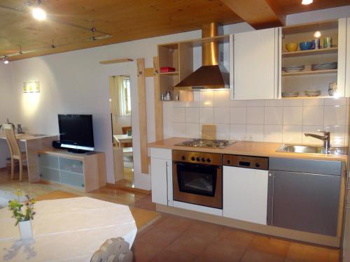 贝曹艾艮德尔旅馆公寓的厨房配有水槽和炉灶 顶部烤箱