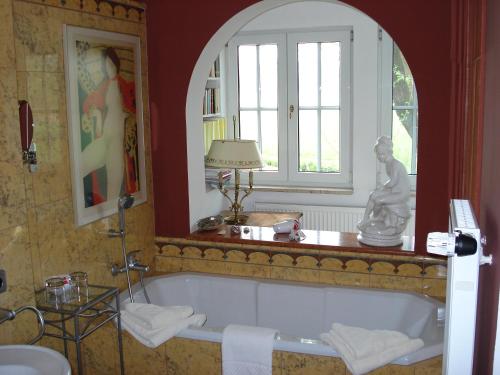 Neudrossenfeld伯格穆酒店及餐厅的带浴缸的浴室和窗户。