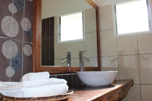 塔那那利佛里维埃拉花园酒店的浴室配有盥洗盆、镜子和毛巾