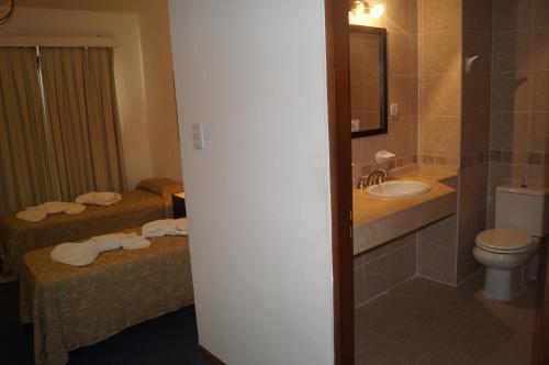 特尔马斯德里奥翁多Grand Hotel by MH的浴室设有两张床、一个水槽和厕所