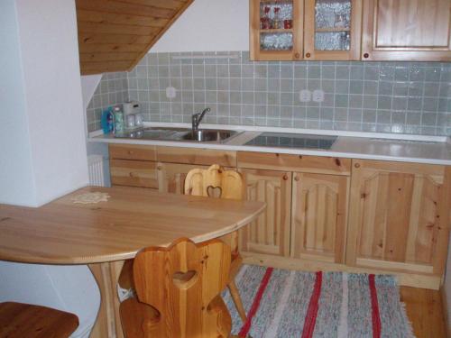 DovjeApartmaji Pr Potovcnk的厨房配有木桌和水槽。