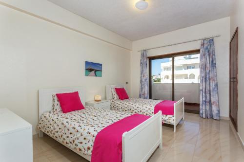 珀彻斯Andorinha 2 bedroom apart-close to the sea-Algarve的一间卧室设有两张床和窗户。