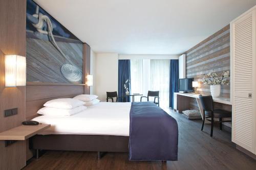 梅登布利克美戴木布里克酒店的酒店客房设有一张大床和一张书桌。