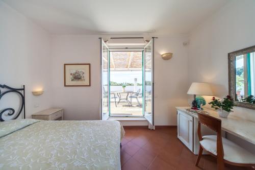莫诺波利Villa Carenza的一间卧室配有一张床和一张带镜子的书桌