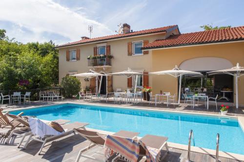 杜伊诺博尔戈杜伊诺别墅酒店的别墅设有游泳池和庭院家具。