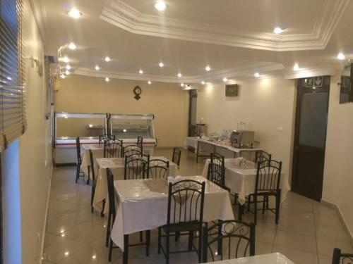 马普托Pensao Marhaba Residencial的餐厅内带桌椅的用餐室
