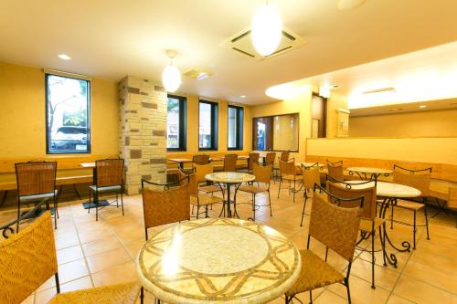 名古屋名古屋荣东R&B酒店的餐厅设有桌椅和窗户。