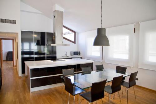 特鲁埃尔托里科阿曼特斯旅游公寓的厨房以及带玻璃桌和椅子的用餐室