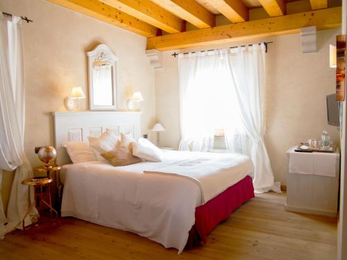 维托里奥·威尼托爱丽丝瑞莱斯内勒维涅住宿加早餐旅馆的卧室配有一张大白色床和窗户