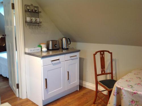 海华德希思Field Cottage B&B的厨房配有柜台、桌子和椅子