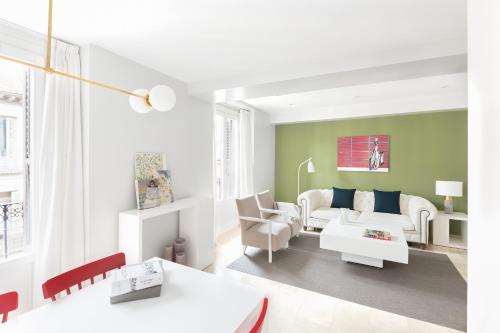 马德里卡雷塔斯公寓的客厅配有白色家具和绿色墙壁。