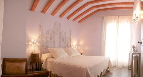 拉斯卡弗里亚Zaguan的一间卧室配有一张带白色床单的床和一扇窗户。