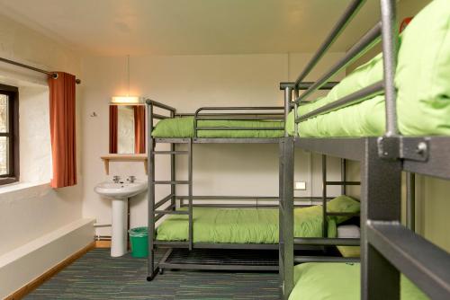 PostbridgeYHA达特穆尔旅舍的客房设有三张双层床和盥洗盆。