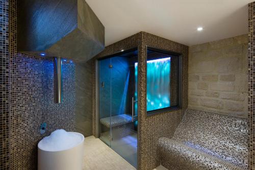 巴黎Hotel & Spa de Latour Maubourg的带淋浴的浴室和玻璃门