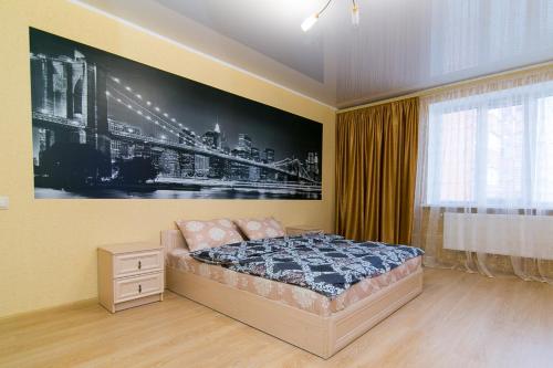 苏梅VIP Apartment on Novomestenskaya的卧室配有一张床,墙上挂有绘画作品