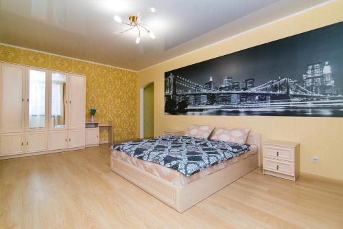 苏梅VIP Apartment on Novomestenskaya的卧室配有一张床,墙上挂有绘画作品