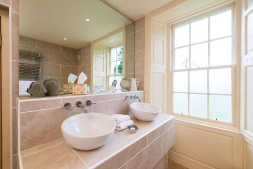 柯克宾卡文斯乡村别墅的一间带两个盥洗盆和窗户的浴室