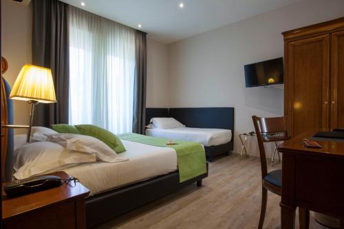 拉帕洛阿索托丽亚酒店的酒店客房设有两张床、一张桌子和一台电视。
