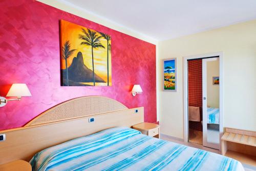 圣多米诺拉特拉蒙塔纳酒店的一间卧室配有一张床和粉红色的墙壁