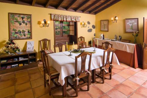 塔科龙特萨尔瓦多卡萨乡村酒店的一间配备有白色桌椅的用餐室