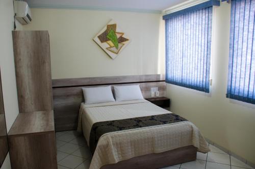 里约布兰科Hotel Majú的一间小卧室,配有床和2个窗户