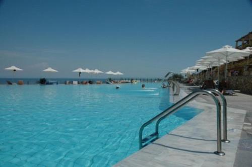 斯卡拉Villa Apostolata的一个带蓝色水和白色遮阳伞的游泳池