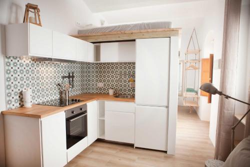 塔里法2 - LA ESQUINA AZUL de TARIFA - ENJOY TARIFA的一间铺有木地板的白色橱柜小厨房