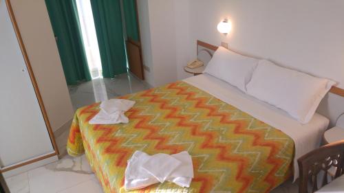 里米尼梅莫里酒店的一间卧室配有一张床,上面有两条毛巾