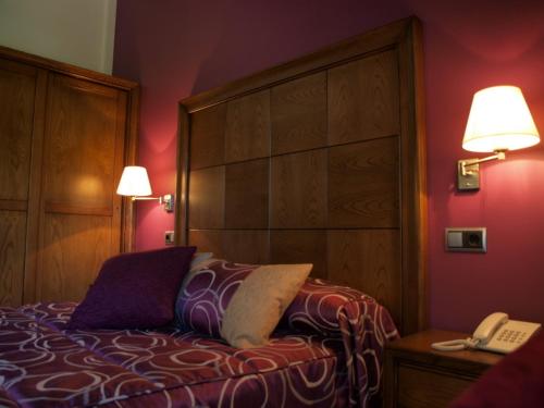 Sahun卡萨初莉安酒店的一间卧室配有一张床、一部电话和两盏灯。