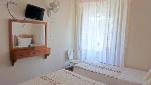 里斯本银色膳宿酒店的一间卧室设有两张床、镜子和窗户