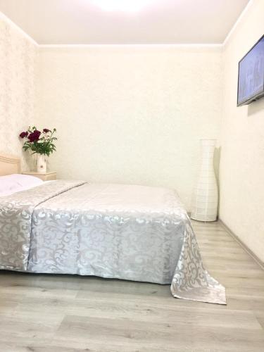 敖德萨Vilari Odessa的一间白色的卧室,配有一张床和花瓶