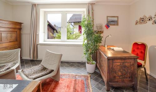 特里森2,5 Zimmer Ferienwohnung mit Küche/Bad的客厅配有书桌和窗户。