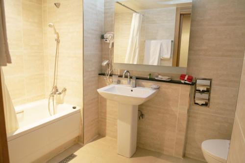 大邱大邱联合之旅酒店的一间带水槽、浴缸和卫生间的浴室