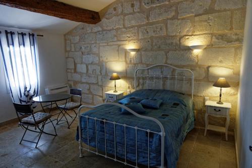 阿尔勒勒马斯德艾斯纳德旅馆的一间卧室设有一张床和石墙