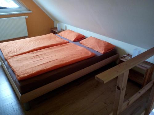 格拉尔-米里茨Haus Sonnenschein的一张带橙色床单和枕头的床