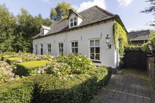 许尔斯霍斯特B&B Het Wellnest的前面有花园的白色房子
