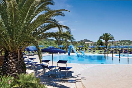 费拉约港Hotel Airone isola d'Elba的度假村的游泳池设有椅子和滑梯