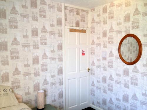 斯皮克利物浦机场民宿的一间有门的房间,墙上挂着照片